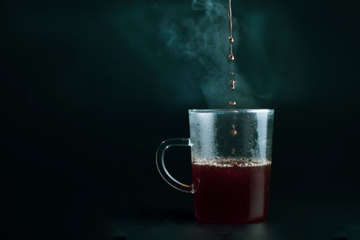 Close-up of coffee cup against black background