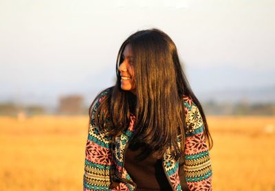 Woman standing on field against sky