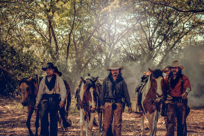 Men and horses in forest