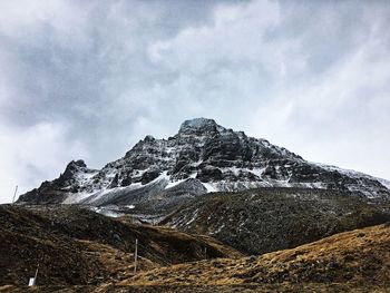 Low angle view of snowcapped mountains against sky