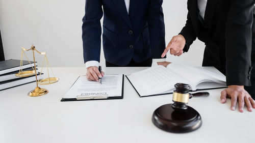 Midsection of man holding camera on table