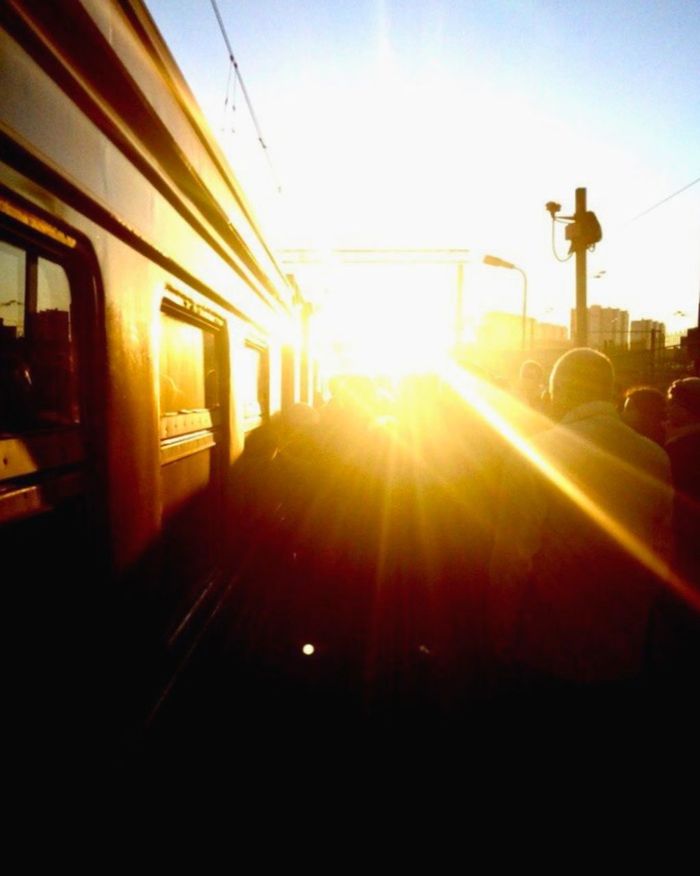 sun, sunset, sunbeam, lens flare, sunlight, built structure, architecture, transportation, building exterior, sky, street light, car, city, street, mode of transport, silhouette, land vehicle, public transportation, railroad track, road