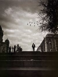 Silhouette of people against cloudy sky