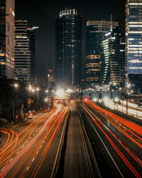 High angle view of light trails on city street amidst buildings