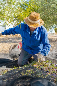 Rear view of man wearing hat standing on field