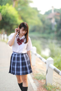 Young woman standing against railing