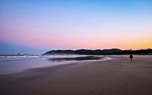 Scenic view of beach against clear sky during sunset