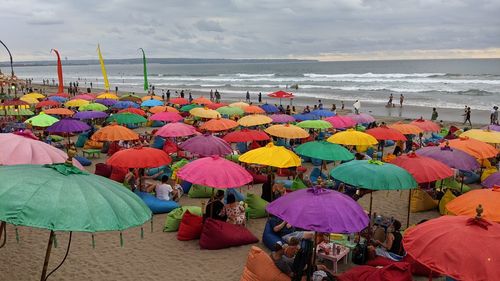 Group of people on beach against sky