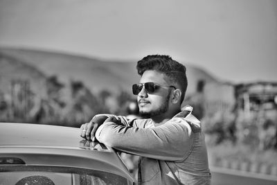 Portrait of young man wearing sunglasses against sky