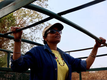 Portrait of woman wearing sunglasses standing against sky