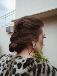 Rear view of woman looking away against wall