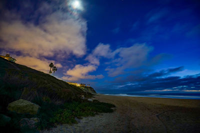 Road amidst land against sky at sunset