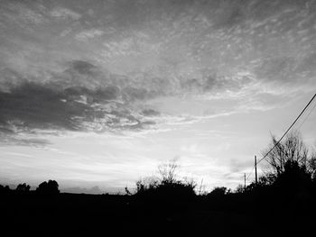 Low angle view of silhouette trees against sky