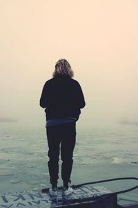 Rear view of a man standing on beach