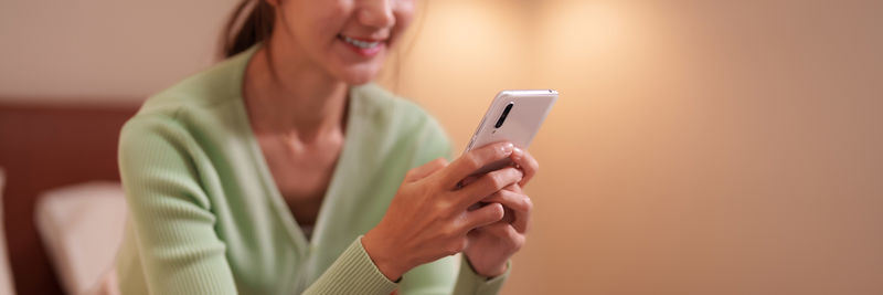 Midsection of woman using mobile phone