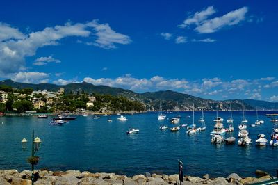 Boats moored on sea against blue sky