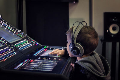 Cute boy mixing music in recording studio