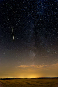 Scenic view of landscape against star field at night