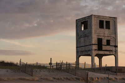Exterior of abandoned building against sky during sunset
