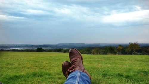 Low section of man relaxing on grassy landscape