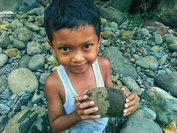 Portrait of cute boy on rock