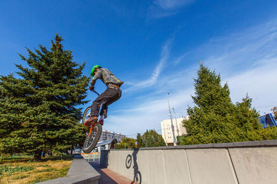 Low angle view of man performing bicycle stunt against sky