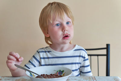 Portrait of cute boy eating food at home