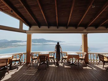 Rear view of man sitting on table in sea