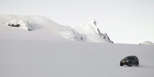 Customised suv ploughing through snowy landscape on icelandic glacier