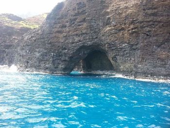 Rock formation in sea against sky