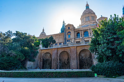 Low angle view of national palace in barcelona with blue sky.