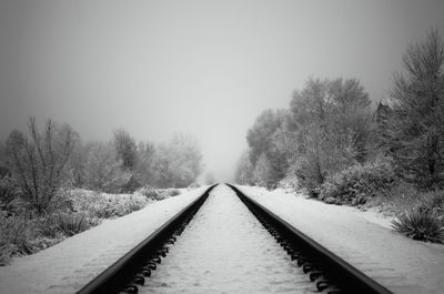 View of railroad tracks against clear sky during winter