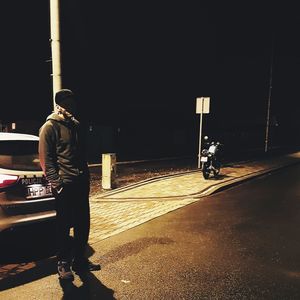 Rear view of man standing on street at night