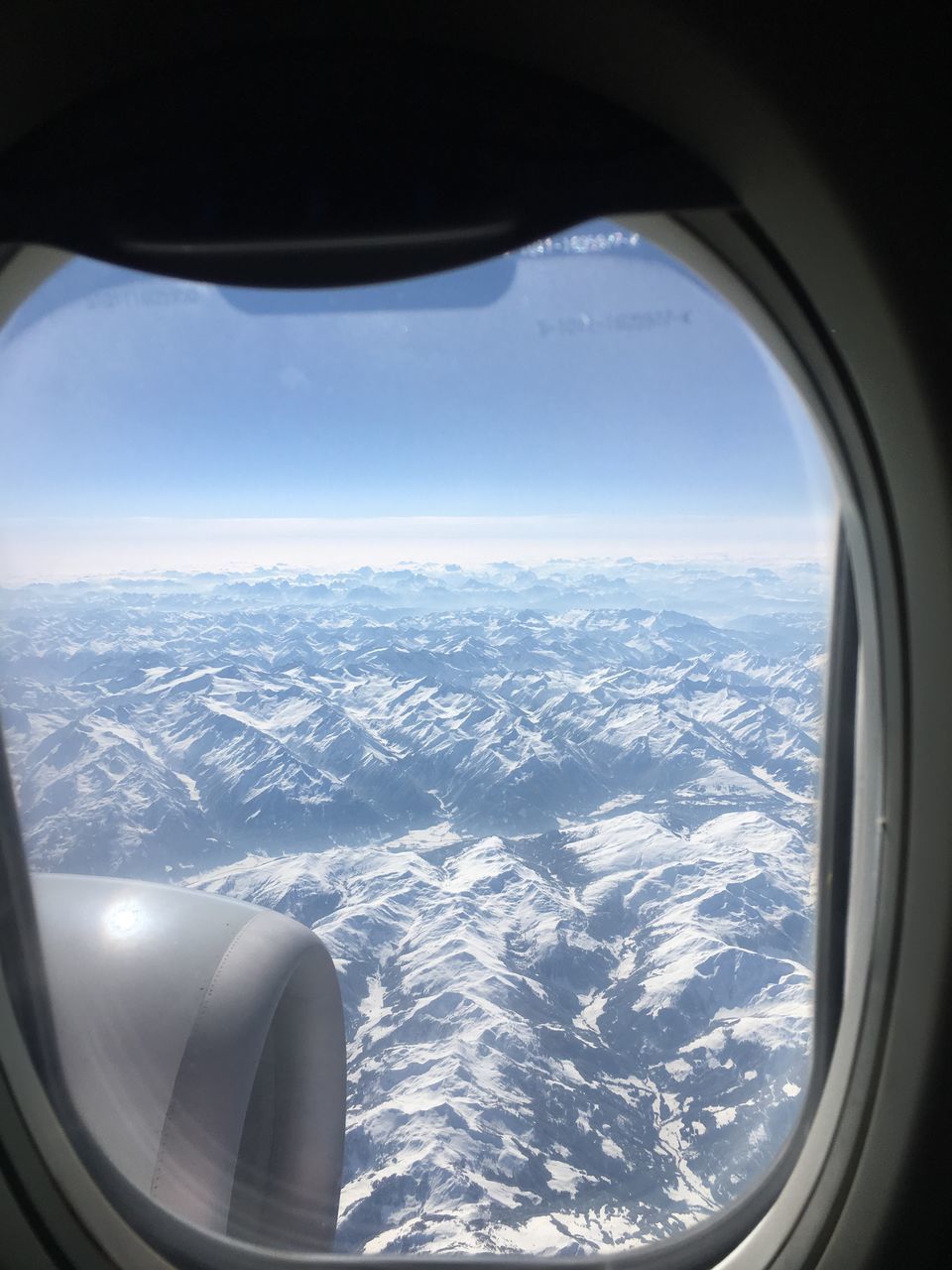 AERIAL VIEW OF MOUNTAINS SEEN THROUGH AIRPLANE WINDOW