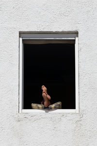 Full length of woman on window of building