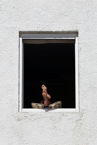 Low section of men with feet up on window