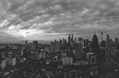 View of cityscape against cloudy sky