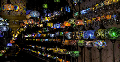 Multi colored lanterns hanging in shelf at market stall