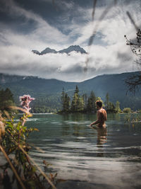 Shirtless man standing in lake