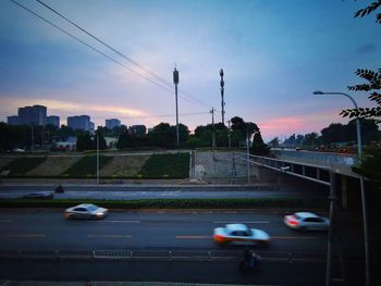 Traffic on road at sunset