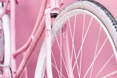 Close-up of bicycle against pink wall