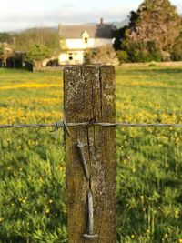 Close-up of wooden post of fence on grassy field