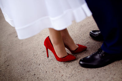 Low section of bride and groom standing on floor