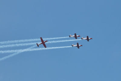 Low angle view of airplane flying against blue sky