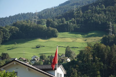 Scenic view of trees and houses against sky