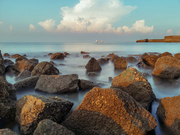 Scenic view of rocks at beach against sky