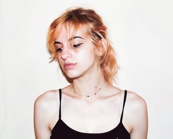 Close-up of young woman against white background
