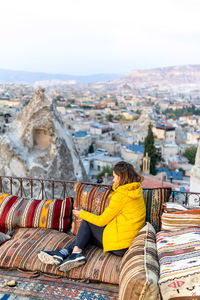 Woman is enjoying the glass of wine on the balcony at sunset