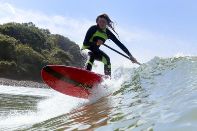 Female sup surfer on a wave