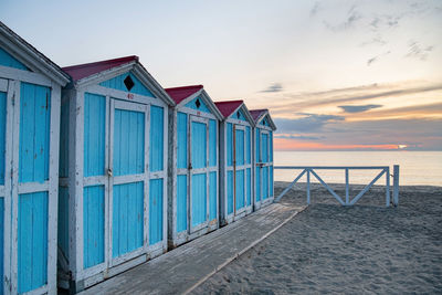 Beach hut against sky during sunset. old blue houses on the sea shore 